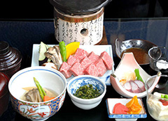 A set meal including premium Hida beef grilled on a ceramic plate 